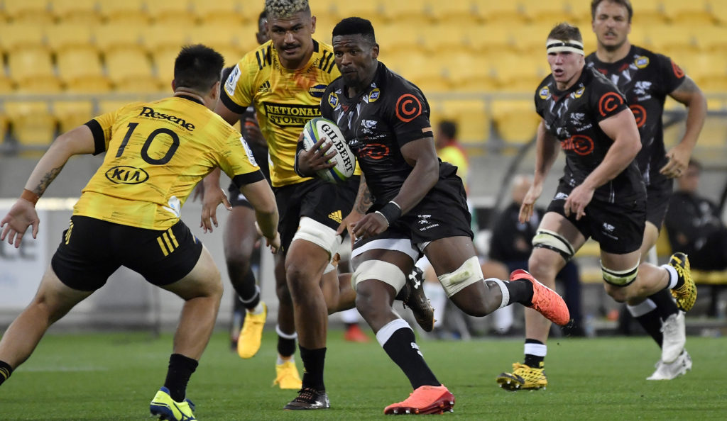 Bok hopeful Sikhumbuzo Notshe of the Sharks avoids a tackle by Jackson Garden-Bachop of the Hurricanes during the round 3 Super Rugby match between the Hurricanes and the Sharks at Westpac Stadium