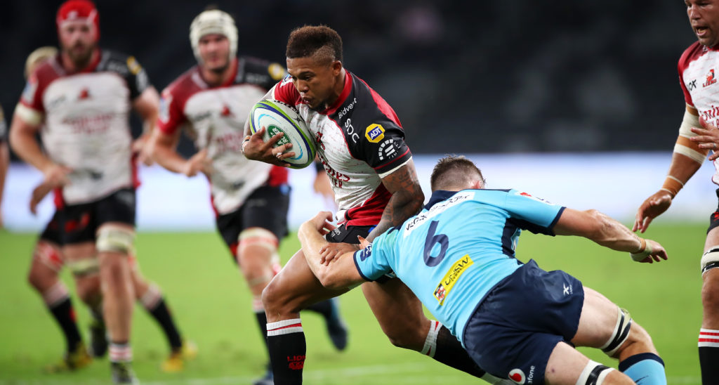 Elton Jantjies of the Lions passes as he is tackled during the round five Super Rugby match between the Waratahs and the Lions at Bankwest Stadium