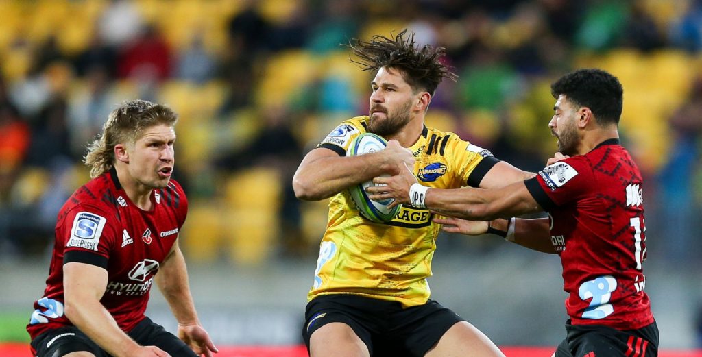 WELLINGTON, NEW ZEALAND - JUNE 21: Kobus van Wyk of the Hurricanes is tackled by Jack Goodhue and Richie Mo'unga of the Crusaders during the round 2 Super Rugby Aotearoa match between the Hurricanes and the Crusaders at Sky Stadium on June 21, 2020 in Wellington, New Zealand. (Photo by Hagen Hopkins/Getty Images)