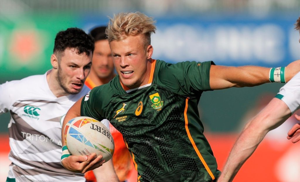 South Africa's JC Pretorius fends off the Ireland defense on day one of the Dubai Emirates Airline Rugby Sevens 2021 men's competition on 3 December, 2021. Photo credit: Mike Lee - KLC fotos for World Rugby/BackpagePix