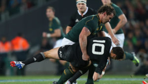 AUCKLAND, NEW ZEALAND - SEPTEMBER 14: Bismarck Du Plessis of South Africa hits Dan Carter of the All Blacks during The Rugby Championship match between the New Zealand All Blacks and the South African Springboks at Eden Park on September 14, 2013 in Auckland, New Zealand.