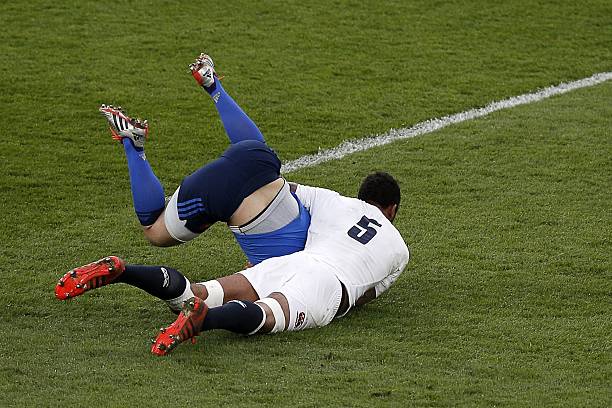 England lock Courtney Lawes (R) tackles France's fly half Jules Plisson (L) during the Six Nations international rugby union match between England and France at Twickenham Stadium, south west of London, on March 21, 2015. AFP PHOTO / ADRIAN DENNIS