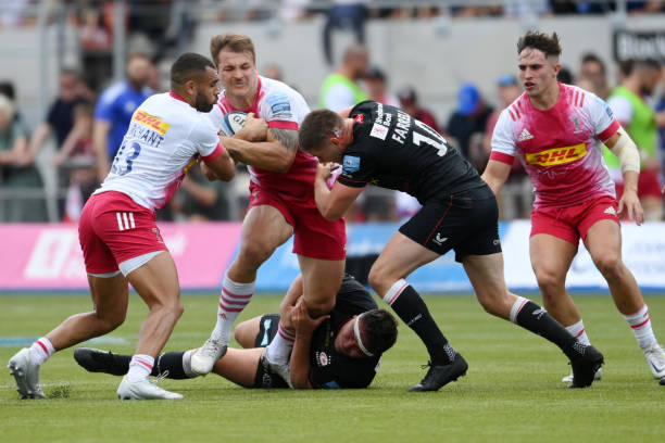 BARNET, ENGLAND - JUNE 11: Andre Esterhuizen of Harlequins is tackled by Jamie George and Owen Farrell of Saracens during the Gallagher Premiership Rugby Semi-Final match between Saracens and Harlequins at StoneX Stadium on June 11, 2022 in Barnet, England.