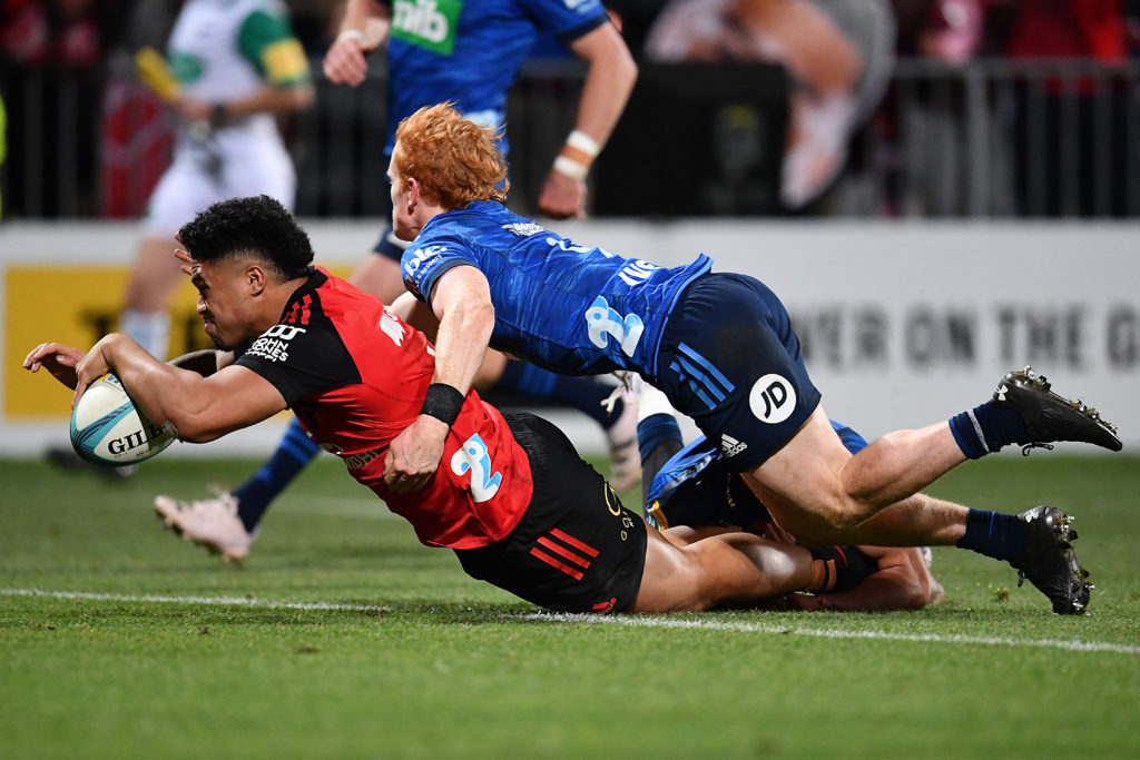 Crusaders' Leicester Fainga'anuku (R) scores a try as Blues' Finlay Christie attempts to tackle him during the Super Rugby Pacific Semi Final match between Crusaders and Blues in Christchurch on June 16, 2023.