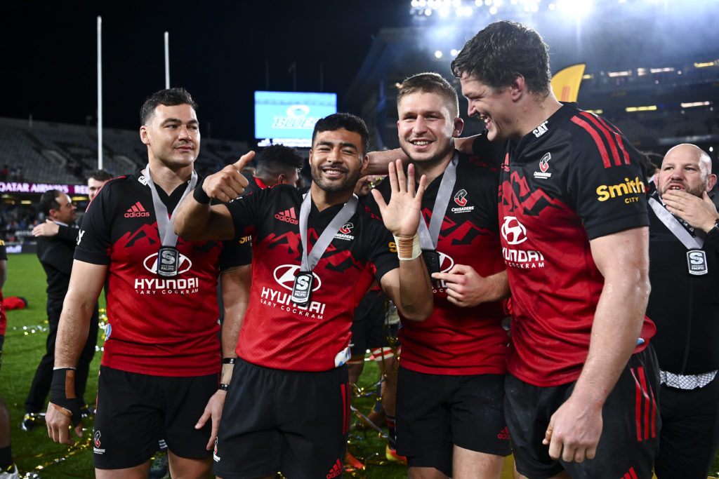AUCKLAND, NEW ZEALAND - JUNE 18: L to R, David Havili, Richie Mo'unga, Jack Goodhue and Scott Barrett of the Crusaders celebrate after the 2022 Super Rugby Pacific Final match between the Blues and the Crusaders at Eden Park on June 18, 2022 in Auckland, New Zealand.