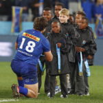 epa10021116 A South African boy presents a winners medal to Neethling Fouche of the Stormers after winning the United Rugby Championship (URC) 2021/22 Final between the Stormers and the Bulls in Cape Town, South Africa, 18 June 2022.