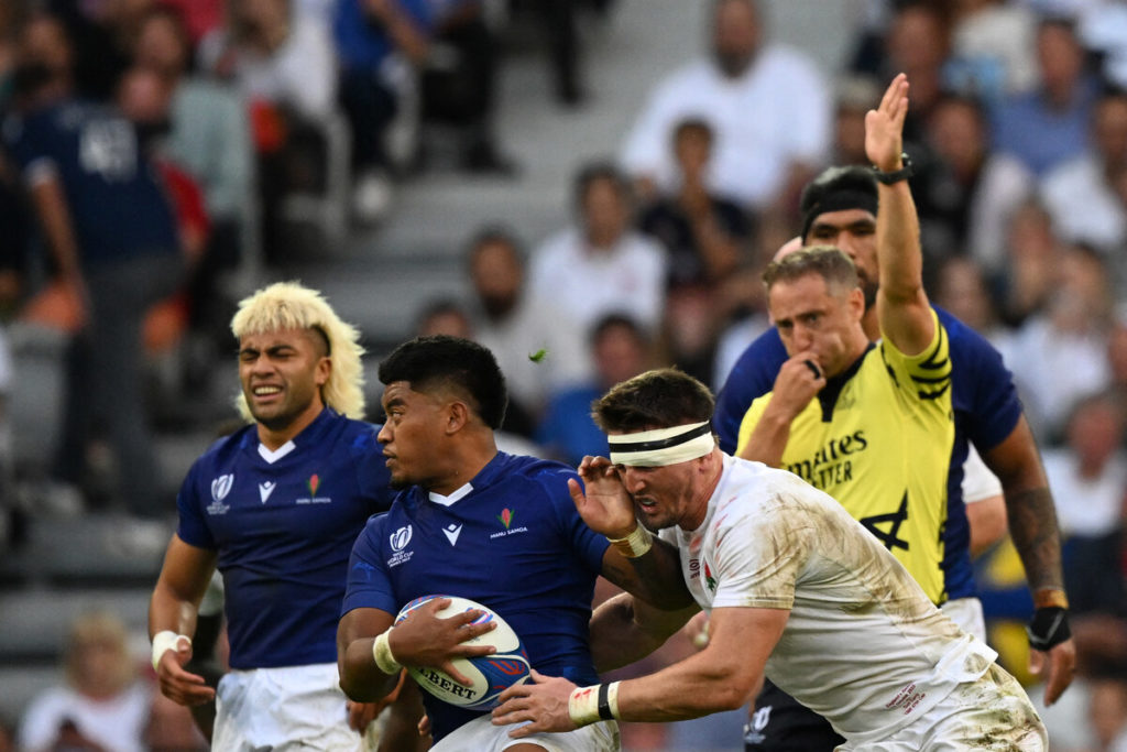Samoa's centre Danny Toala (C) is tackled by England's flanker Tom Curry during the France 2023 Rugby World Cup Pool D match between England and Samoa at the Stade Pierre-Mauroy in Villeneuve-d'Ascq, near Lille, northern France on October 7, 2023.
