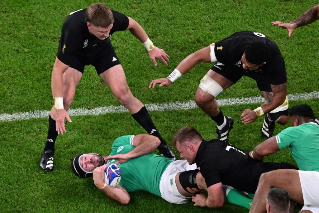 Ireland's number eight Caelan Doris (C) is tackled by New Zealand's openside flanker and captain Sam Cane (2R) during the France 2023 Rugby World Cup quarter-final match between Ireland and New Zealand at the Stade de France in Saint-Denis, on the outskirts of Paris, on October 14, 2023. (