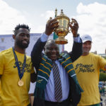 President of South Africa Cyril Ramaphosa (C) lifts the Web Ellis Cup while standing next to South Africa's flanker and captain Siya Kolisi (L) and South Africa's head coach Jacques Nienaber (R) during a welcome ceremony at the Union Buildings in Pretoria on November 2, 2023, after South Africa won the France 2023 Rugby World Cup final match against New Zealand. (Photo by PHILL MAGAKOE / AFP)