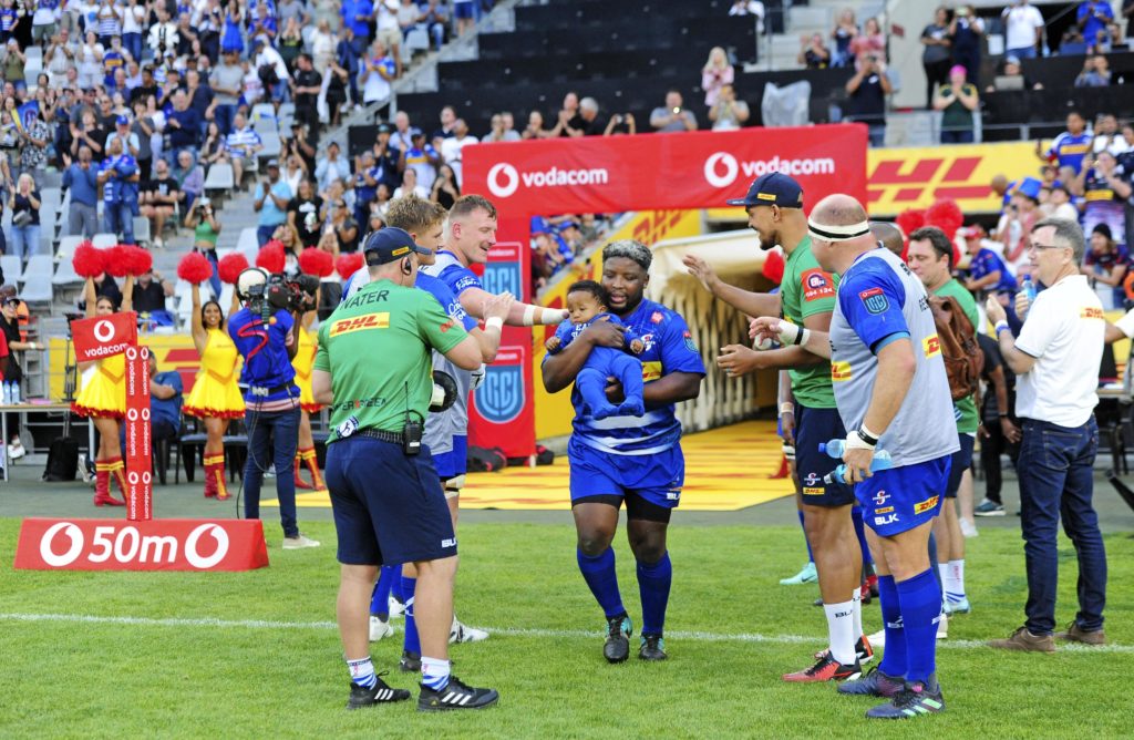 Scarra Ntubeni of the Stormers runs out first with his child to commemorate his 100th game for the Stormers before the 2023 United Rugby Championship game between the Stormers and Sharks at Cape Town Stadium on 30 December 2023 ©Ryan Wilkisky/BackpagePix