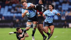 SYDNEY, AUSTRALIA - APRIL 12: Ned Hanigan of the NSW Waratahs is tackled by Dallas McLeod of the Crusaders and Sevu Reece of the Crusaders during the round eight Super Rugby Pacific match between NSW Waratahs and Crusaders at Allianz Stadium, on April 12, 2024, in Sydney, Australia. (Photo by Cameron Spencer/Getty Images)